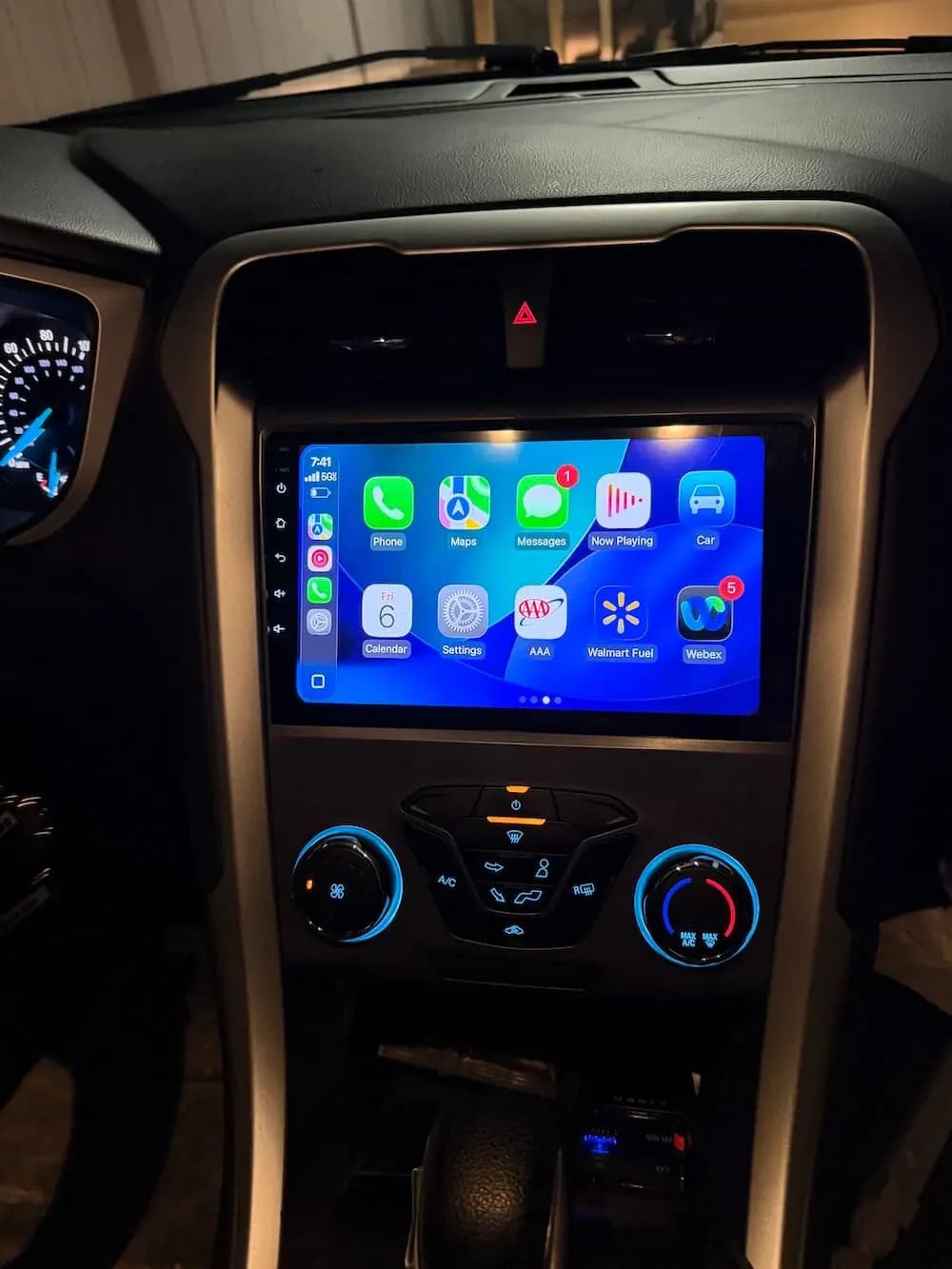 Apple CarPlay home screen on a radio installed above the vehicle climate controls